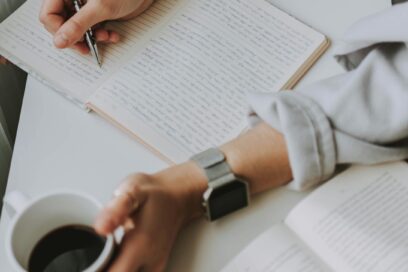 Main qui écrit et qui tient un café - Agrandir l'image, fenêtre modale