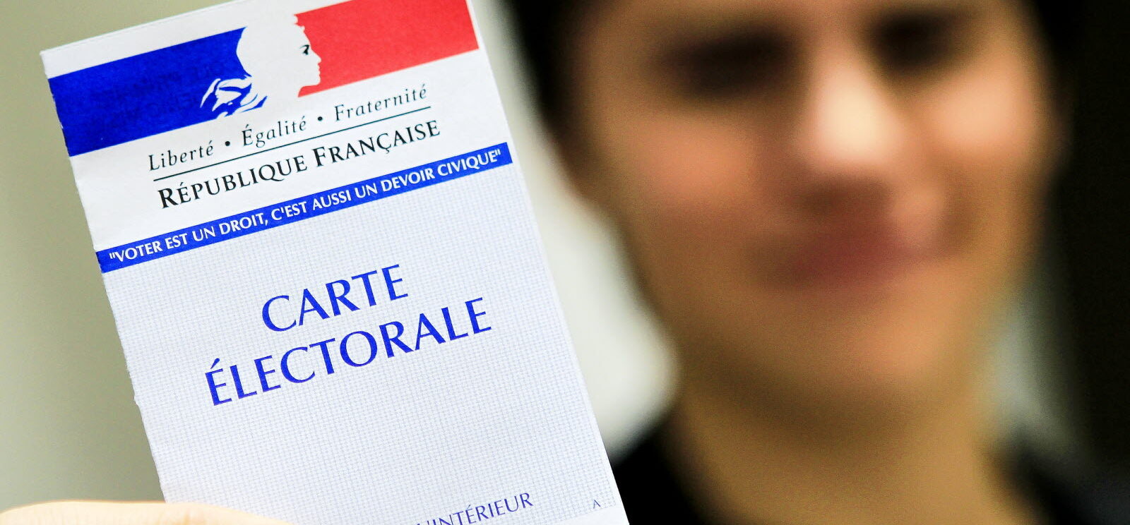 jeune qui montre sa carte électorale